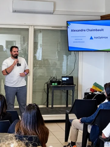 Alexandre Chaimbault anime une formation au micro devant les participants, avec AskOptimize affiché à l’écran.
